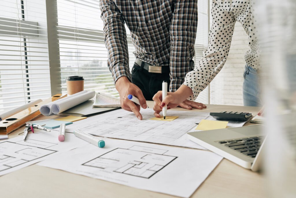 Close-up image of architects working on building blueprint